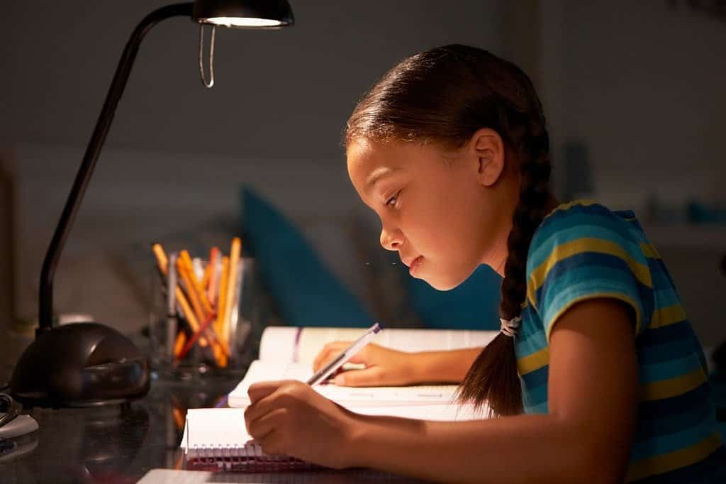 girl reading with a lamp