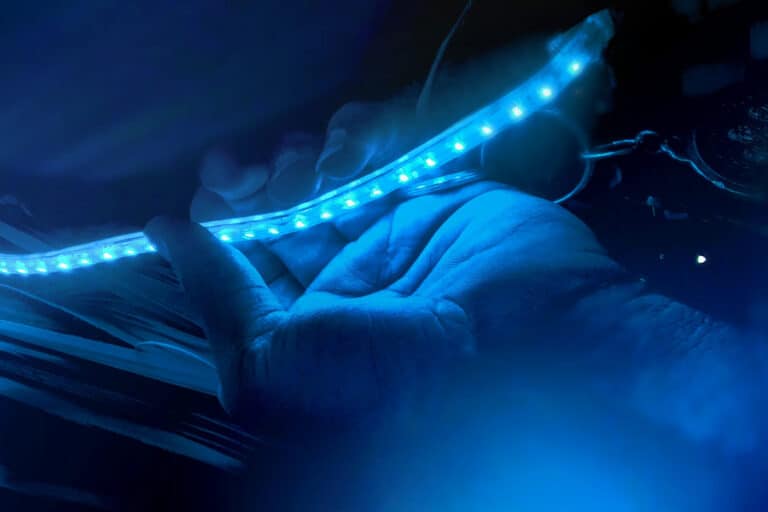 A hand holding a blue LED strip light